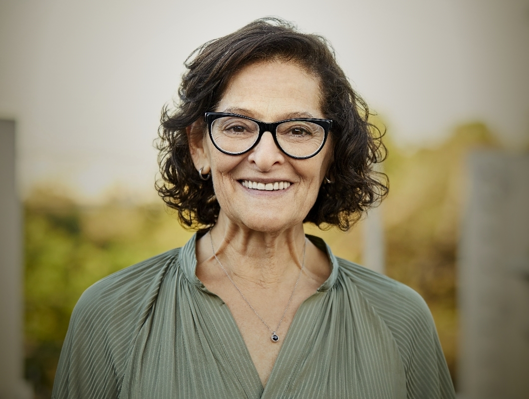 Older lady with glasses smiling. Actor portrayal